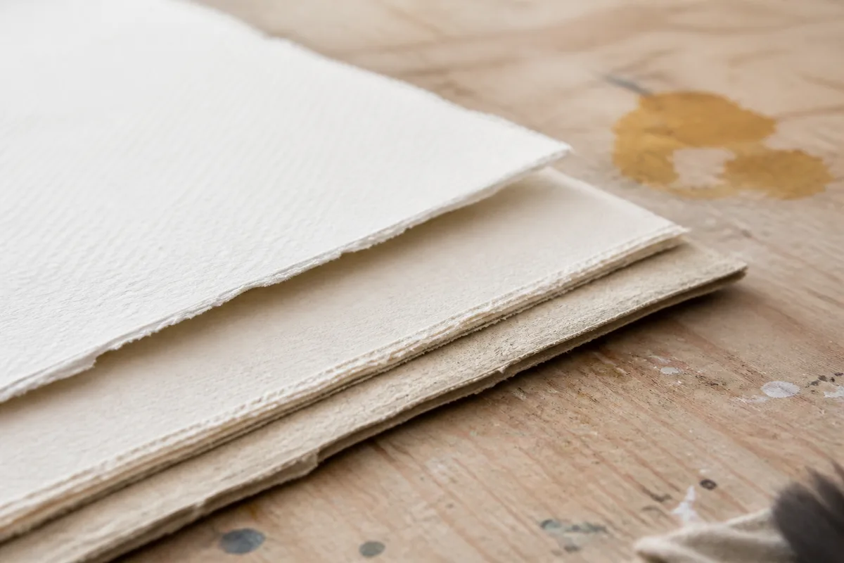 Rame de feuilles d aquarelle de plusieurs épaisseurs posée sur une table d atelier